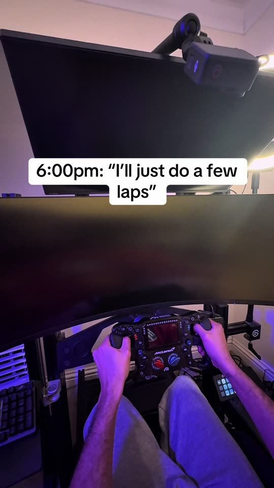 A sim rig in a dark room with the caption about doing a few laps